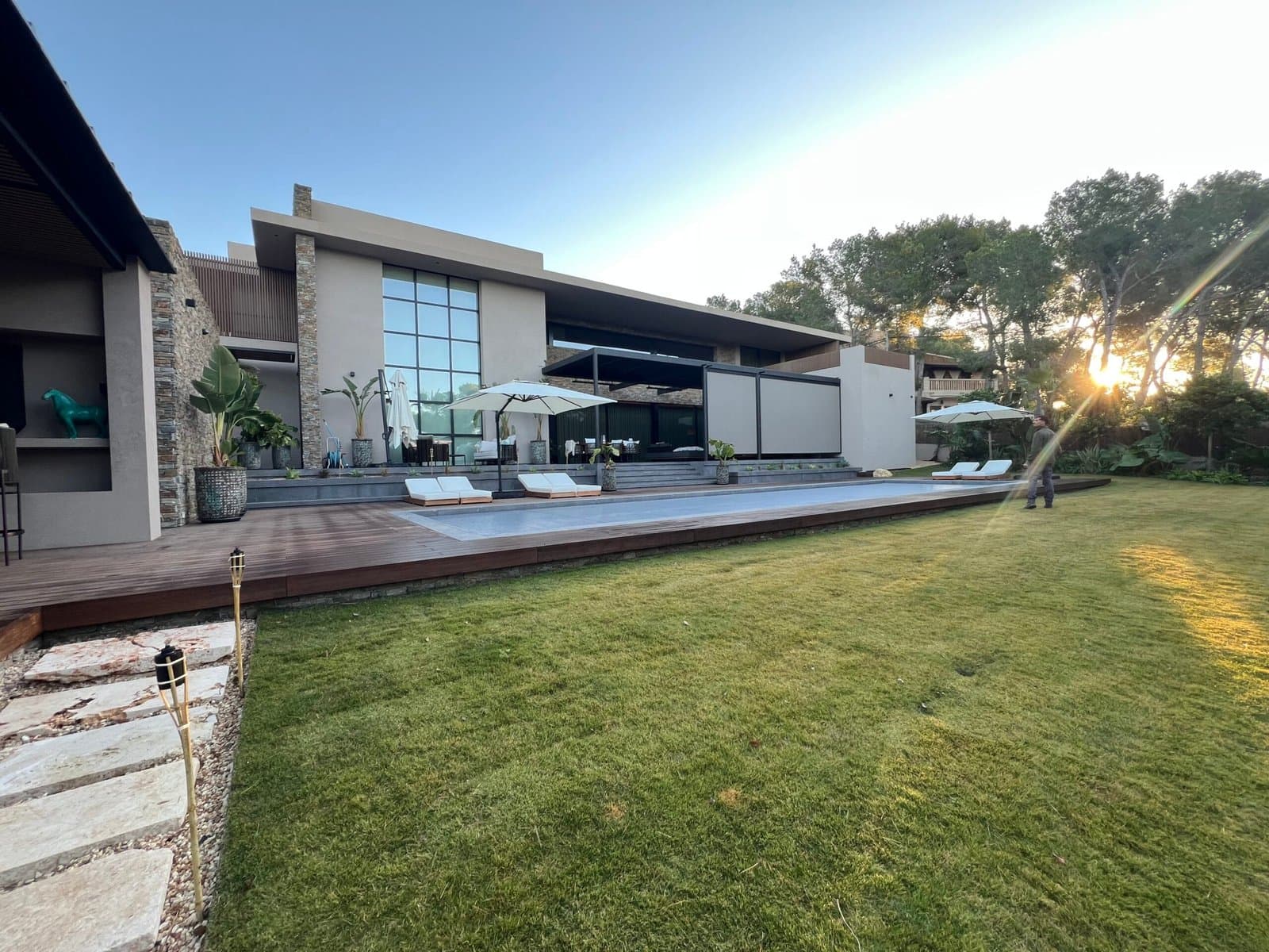 Contemporary Mallorca villa at sunset with pool, lawn and side garden
