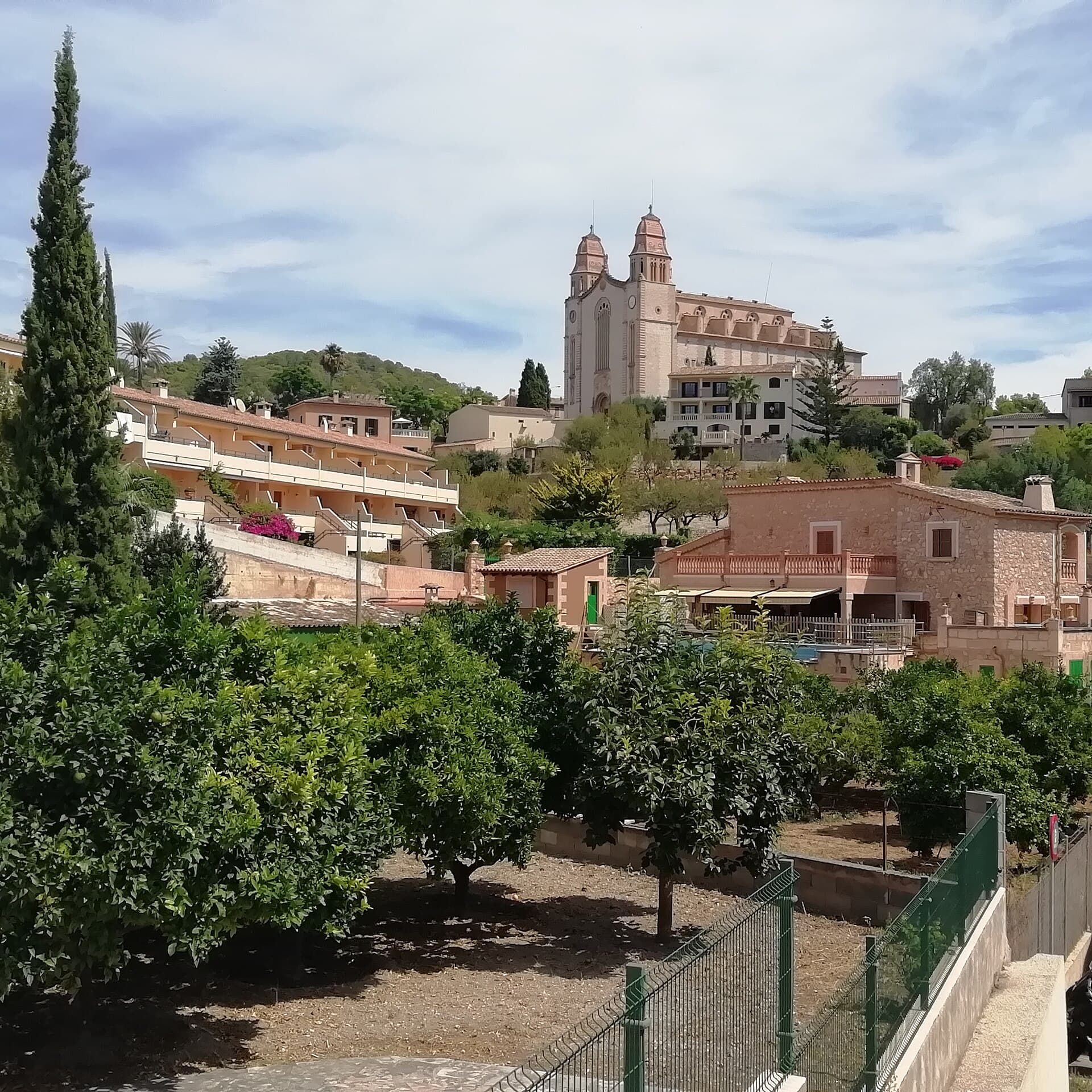 Església de doble torre sobre el poble amb xiprer i tarongers, Calvià, Mallorca